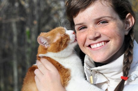 Kat die aan het haar van haar baasje likt